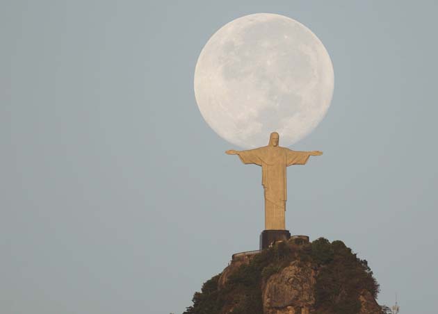 A full moon is seen over the Christ the Redeemer statue in Rio de Janeiro
